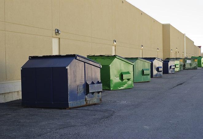 a construction worker moves construction materials near a dumpster in Ashland